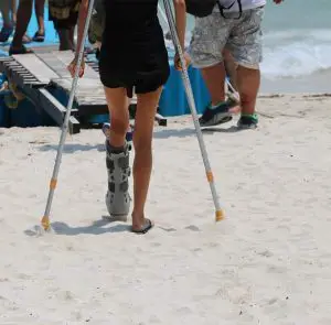 girl-use-crutches-on-beach-worldcrutches