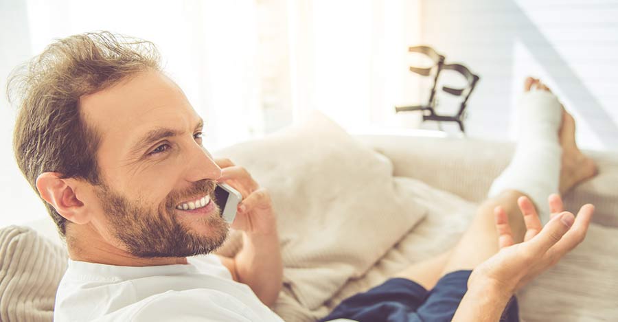 Man-lying-on-the-sofa-with-an-injured-leg-worldcrutches